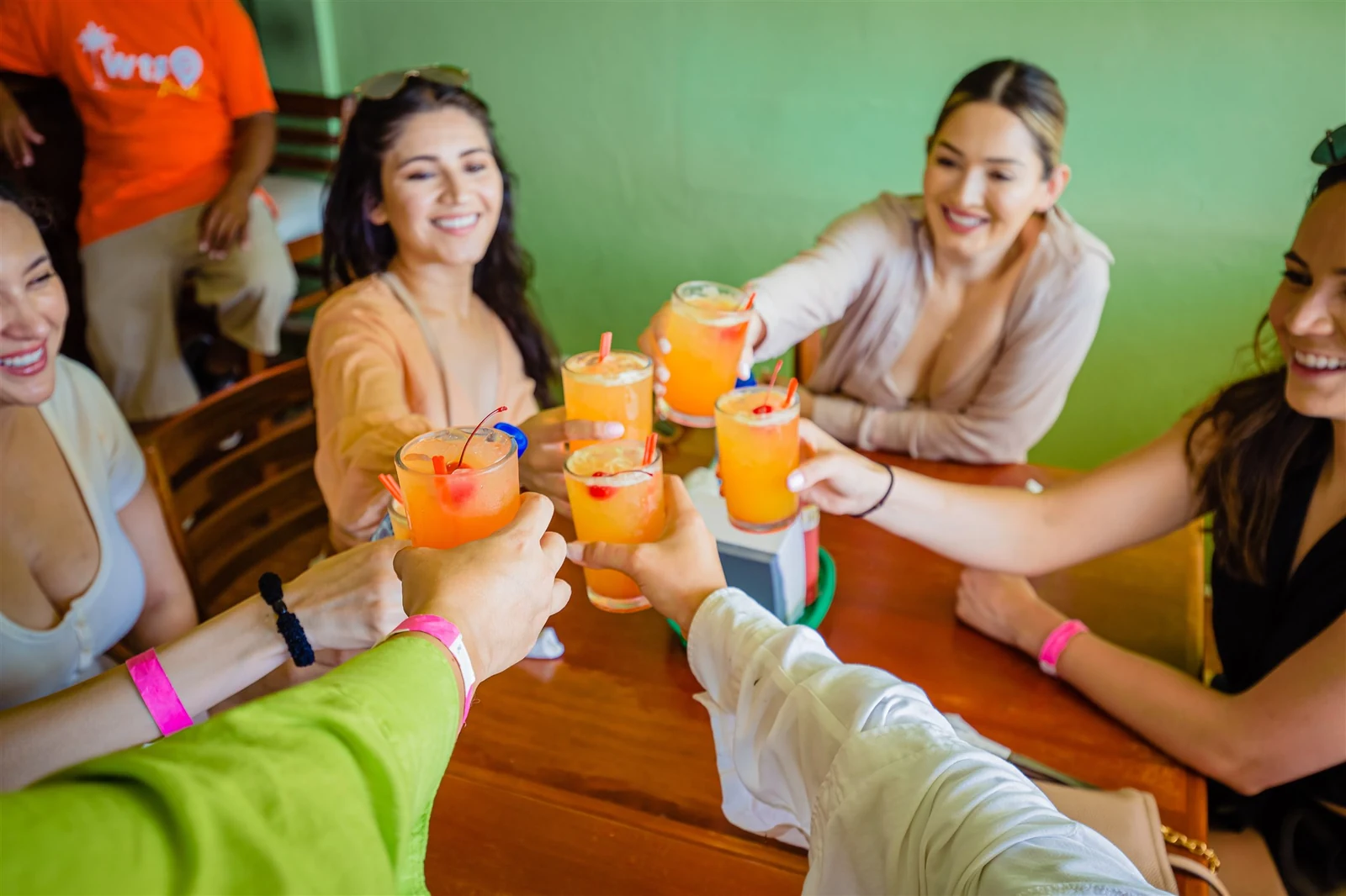 Guests cheering with bright orange drinks on a Belize Food Tours stop